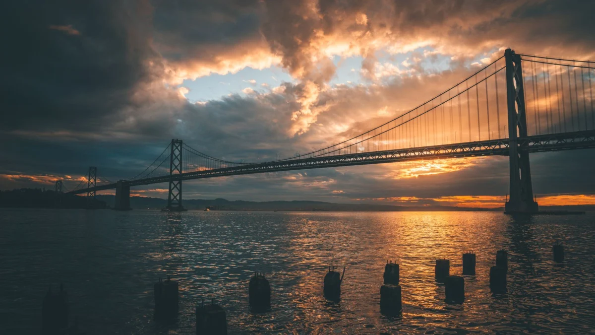 Indrukwekkend uitzicht op de zonsondergang van de Bay Bridge in San Francisco die op het water reflecteert.