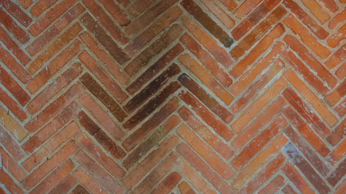 Gedetailleerd uitzicht op een patronen herringbone metselwerk muur met rijke texturen.