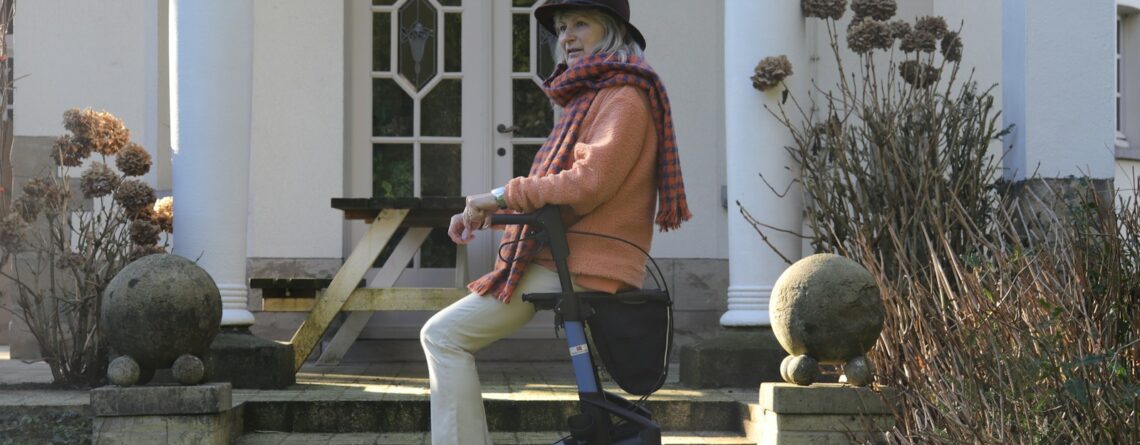 Elderly woman with walker on house steps