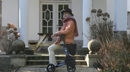 Elderly woman with walker on house steps