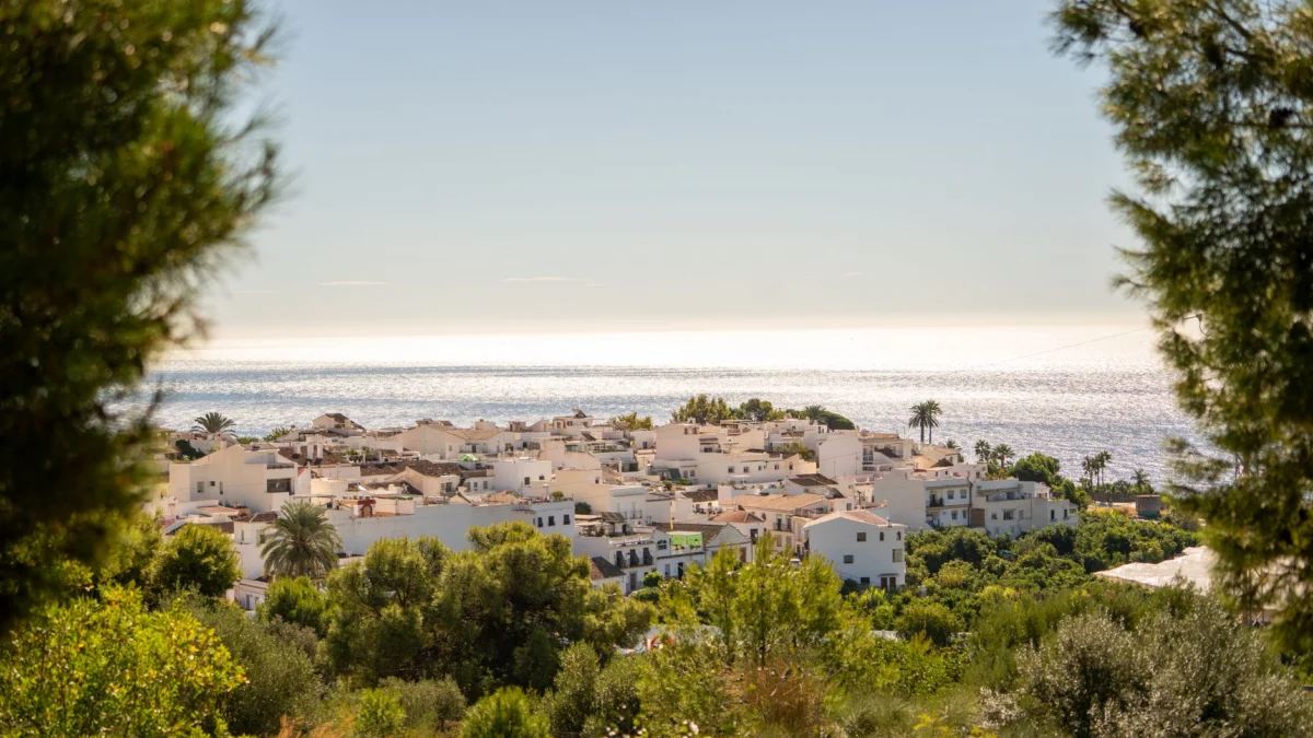 Prachtig uitzicht op de kust van Nerja (Spanje) met de Middellandse Zee en witgekalkte gebouwen omgeven door weelderig groen.