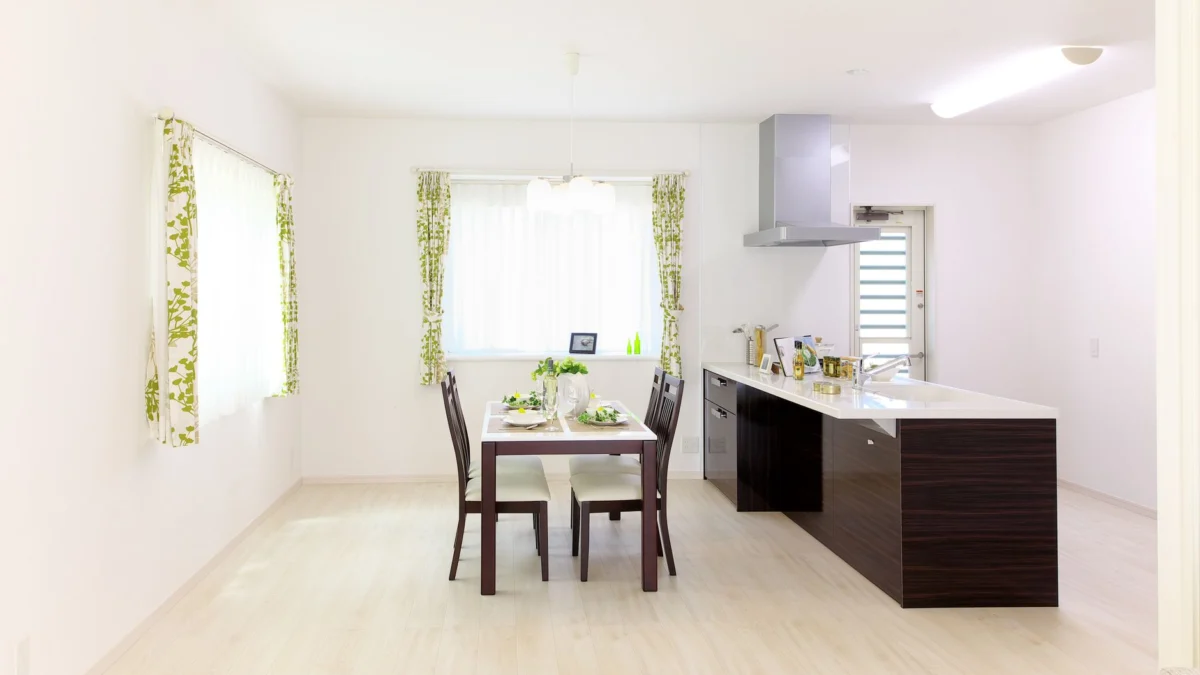 Strakke moderne keuken en eetruimte met natuurlijk licht en minimalistische decoratie.