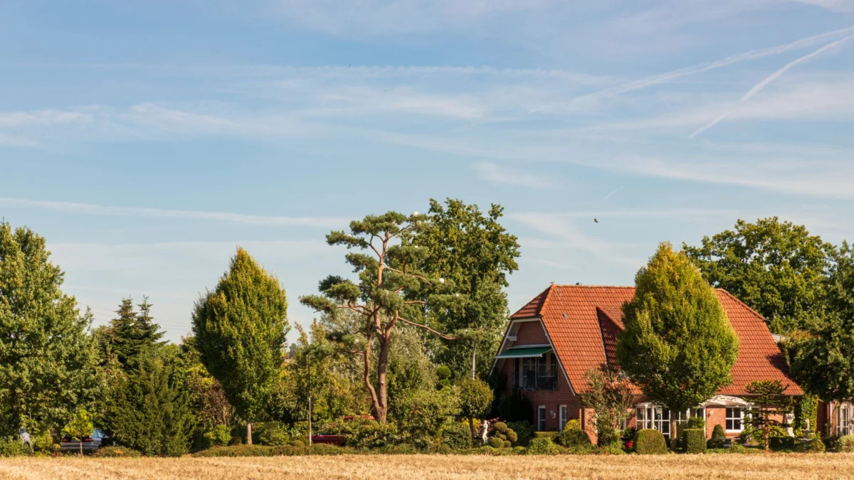 Schilderachtig plattelandslandschap met een charmant bakstenen huis met een rood dak en weelderig groen.