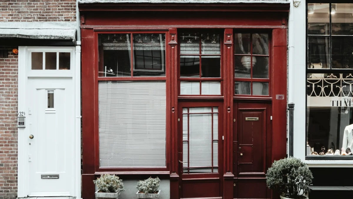 Een charmante gevel van rode baksteen met potplanten in een rustige stedelijke straat.