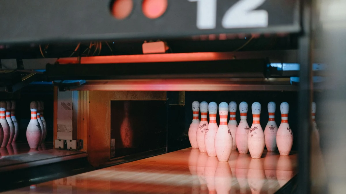 Een levendige opname van verlichte bowlingpinnen, klaar voor actie in baan 12 van een bowlingbaan.