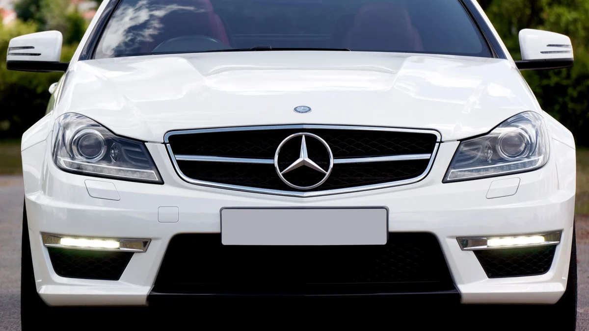 Close-up van een stijlvolle, witte luxe Mercedes-Benz C63 Coupe geparkeerd in de openlucht.