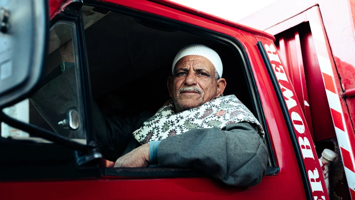 Portret van een oudere man in een voertuig, dat het dagelijks leven in Egypte weergeeft.
