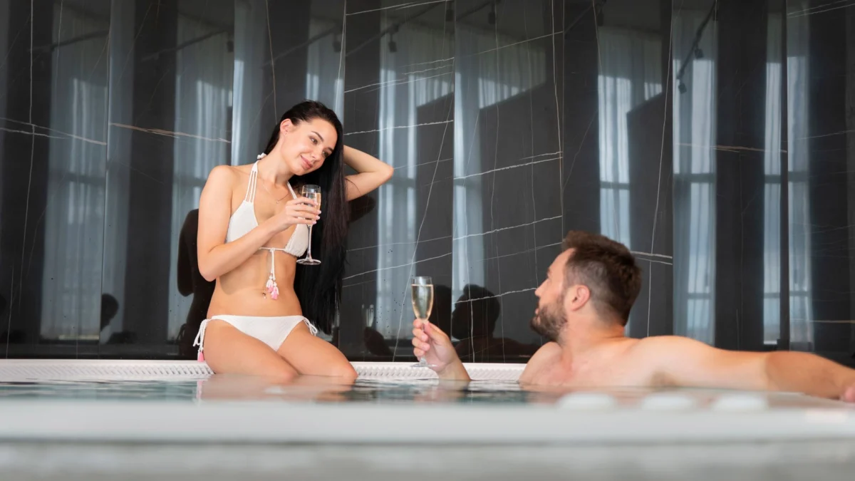 Een jong koppel dat ontspant in een jacuzzi en geniet van hun vakantie met champagne.