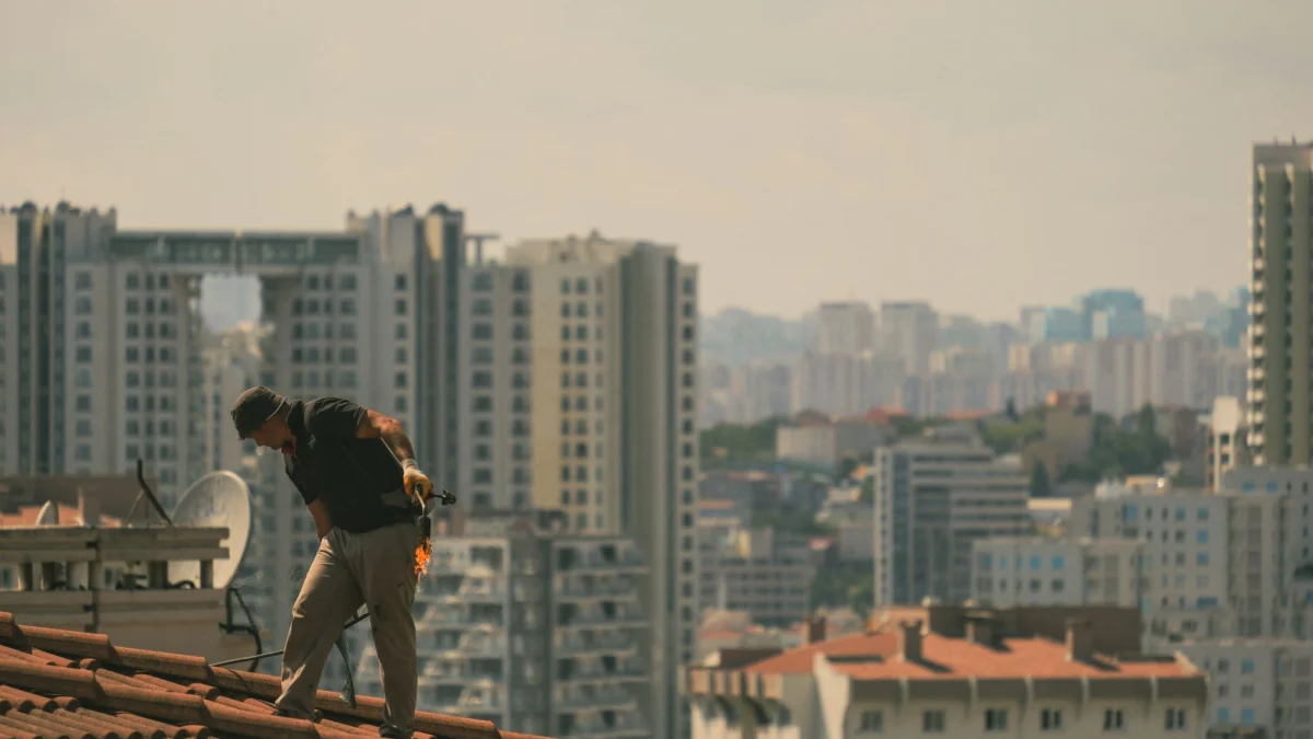 Bouwvakker op een dak in Istanbul met de skyline van de stad op de achtergrond.