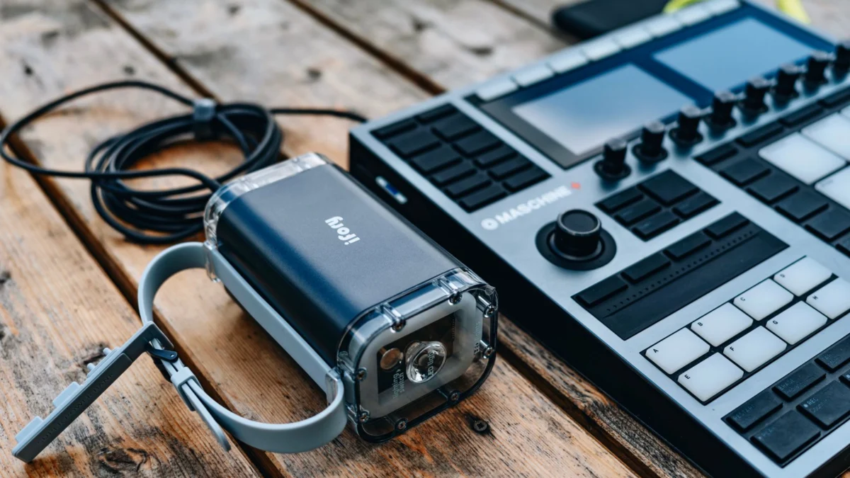 Een moderne DJ-console en draagbare luidspreker geplaatst op een houten oppervlak, ideaal voor muziekopnames.