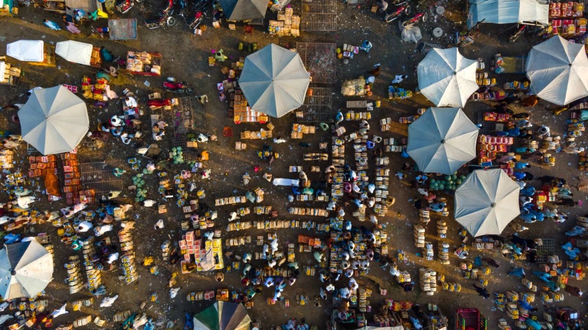Luchtfoto van een bruisende markt in Punjab, met kleurrijke paraplu's en diverse kraampjes.