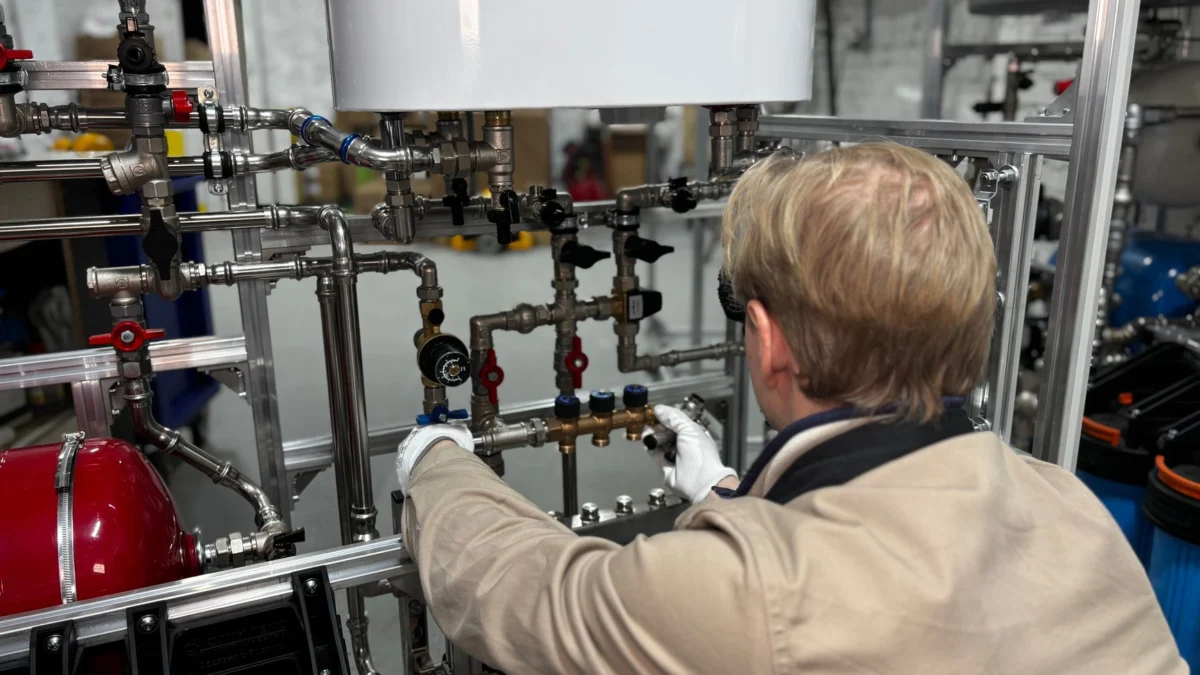 Ingenieur die werkt aan een industrieel leidingsysteem in een fabriek voor verwarming en productie-aanpassing.